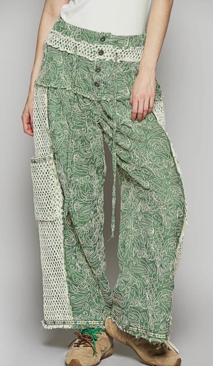 Green boho pants with crochet accents and pockets.